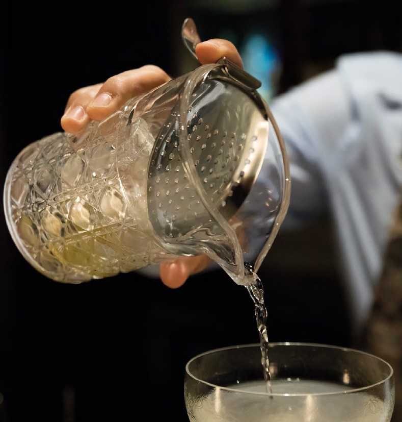 Coador julep dobrado apoiado no gelo dentro do copo misturador