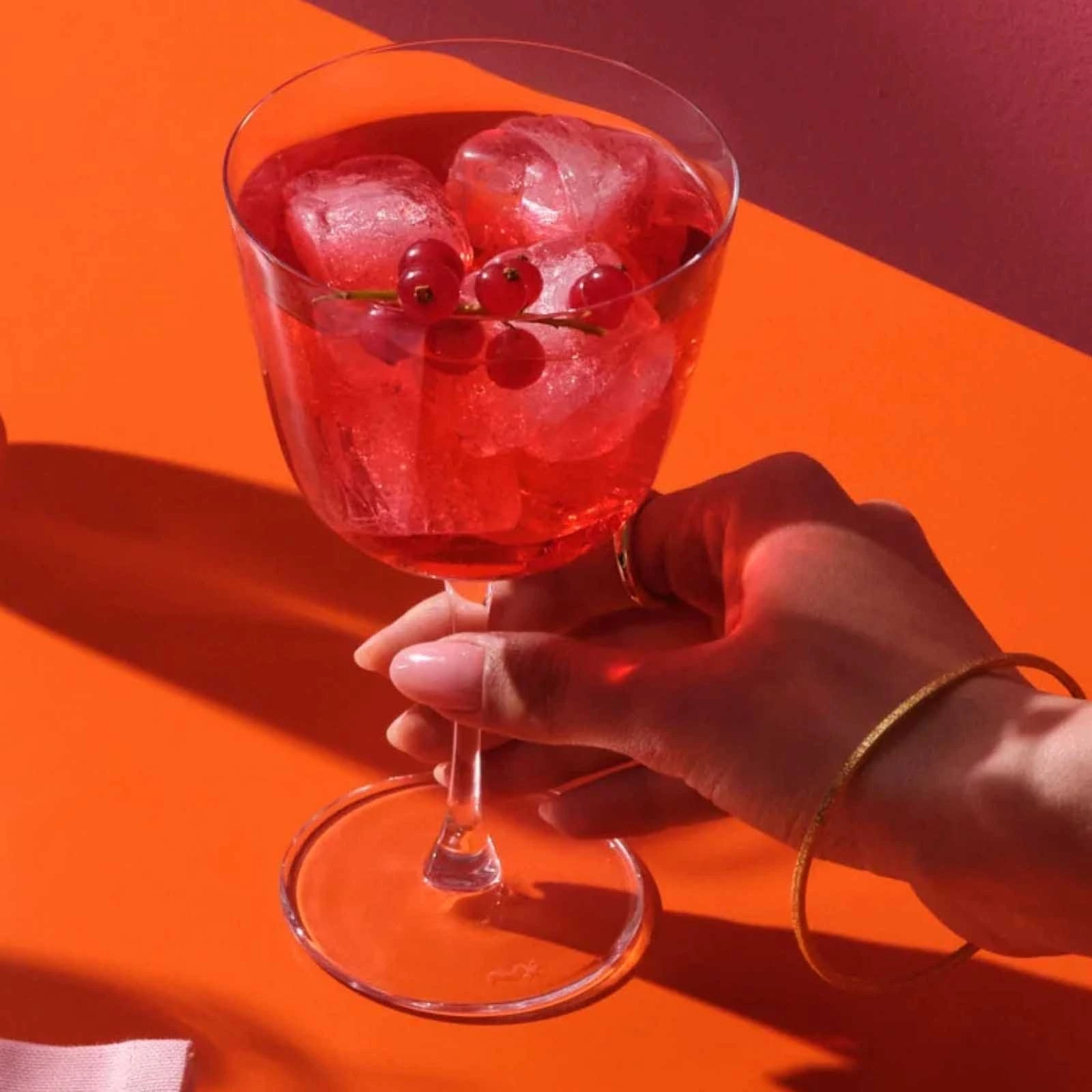 Copo de cocktail Bargiani da NUDE de 33 cl na mão, seguro pelo pé